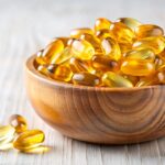 Gelbe Kapseln in einer Holzschale.