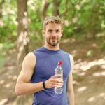 Sportlicher Mann mit Wasserflasche im Freien
