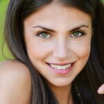 Junge lächelnde Frau mit strahlend grünen Augen.