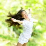 Fröhliche Frau mit langen Haaren in der Natur