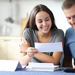 Cuplu zâmbitor cu documente la masă