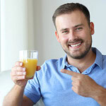 Bărbat ținând un pahar de suc de portocale