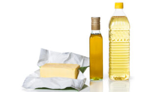 Öl, Butter und Flasche auf weißem Hintergrund