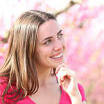 Mulher sorridente em uma paisagem florida de primavera