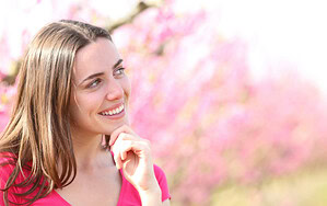 Lächelnde Frau in blühender Frühlingslandschaft